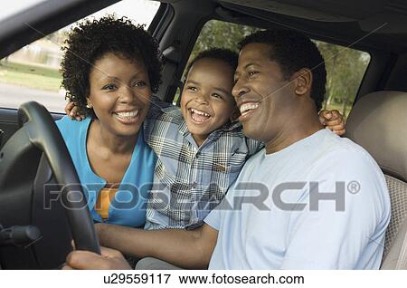 Stock Photo - Family smiling together on driver's seat close-up. Fotosearch