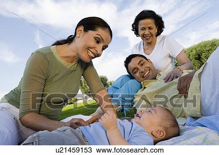 Family with baby (6-12 months) relaxing outdoors View Large Photo Image Stock Image - Family with baby (6-12 months) relaxing outdoors. Fotosearch