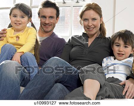 Stock Photo - Family with two children (3-6) on couch (portrait). Fotosearch