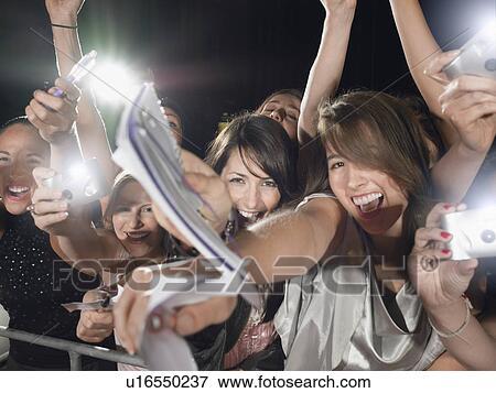 Fans leaning over barrier View Large Photo Image Stock Photo - Fans leaning over barrier. Fotosearch