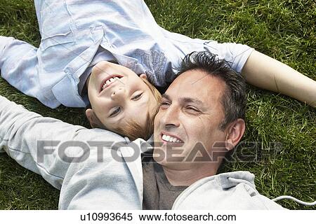 Father and son lying on grass view from above View Large Photo Image Stock Photography - Father and son lying on grass view from above. Fotosearch