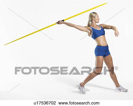 Stock Image - Female athlete preparing to throw javelin side view. Fotosearch
