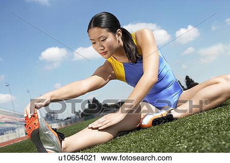 Female athlete stretching on field View Large Photo Image Stock Image - Female athlete stretching on field. Fotosearch