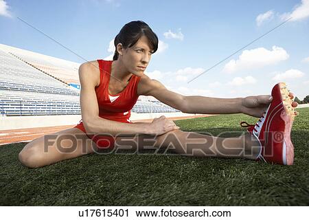 Female athlete stretching on field View Large Photo Image Stock Image - Female athlete stretching on field. Fotosearch