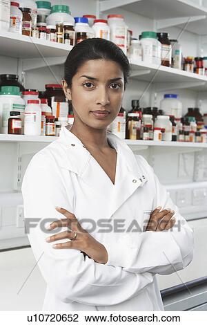 Female lab worker standing pill bottles behind View Large Photo Image Stock Image - Female lab worker standing pill bottles behind. Fotosearch
