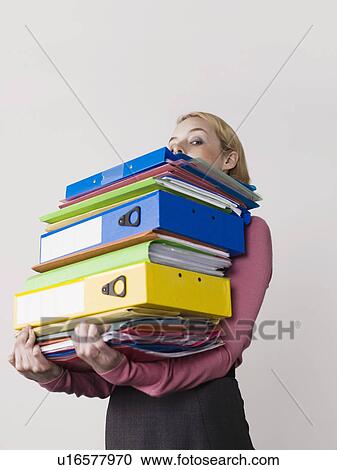 Female office worker carrying heavy binders on white background View Large Photo Image Stock Image - Female office worker carrying heavy binders on white background. Fotosearch