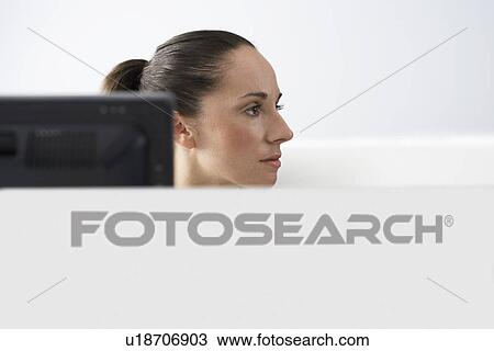 Female office worker sitting behind monitor in office cubicle portrait View Large Photo Image Stock Image - Female office worker sitting behind monitor in office cubicle portrait. Fotosearch