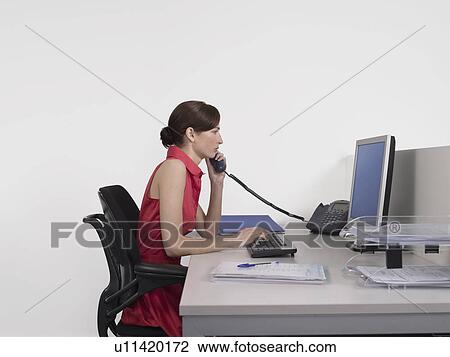 Female office worker using computer at desk in office View Large Photo Image Stock Image - Female office worker using computer at desk in office. Fotosearch