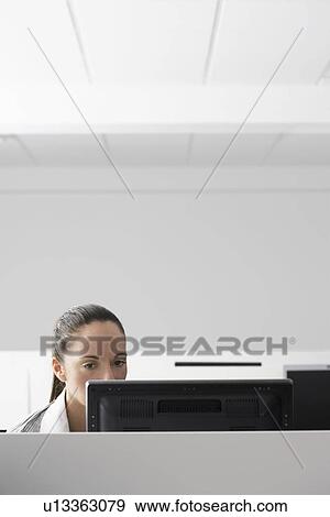 Female office worker using computer in office cubicle View Large Photo Image Stock Photo - Female office worker using computer in office cubicle. Fotosearch
