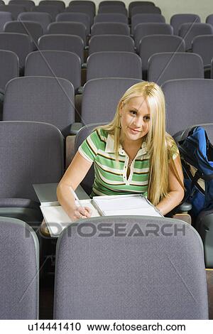 Female student sitting alone in lecture hall (portrait) View Large Photo Image Stock Image - Female student sitting alone in lecture hall (portrait). Fotosearch