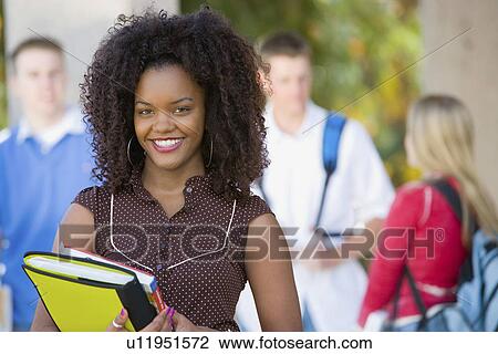 Stock Image - Female student smiling outdoors (portrait). Fotosearch