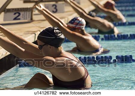 Female swimmers holding onto starting block preparing to swim backstroke View Large Photo Image Stock Image - Female swimmers holding onto starting block preparing to swim backstroke. Fotosearch