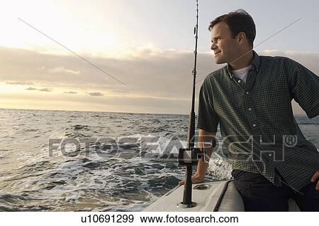 Stock Photo - Fisherman on boat at sea. Fotosearch