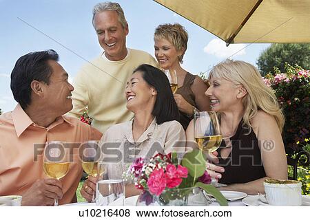 Five friends at table drinking wine at garden party View Large Photo Image Stock Photo - Five friends at table drinking wine at garden party. Fotosearch