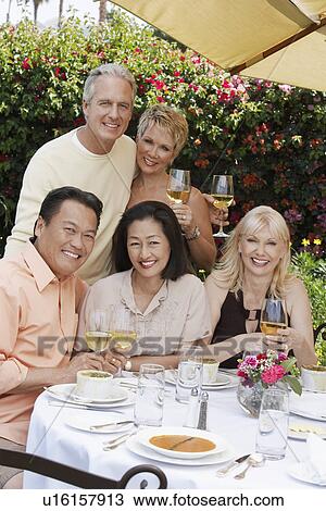 Five friends toasting at dining table outdoors View Large Photo Image Stock Image - Five friends toasting at dining table outdoors. Fotosearch
