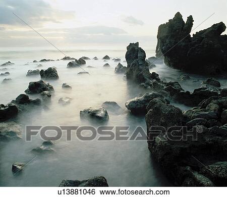 Stock Photograph - Fog among rocks on coastline. Fotosearch