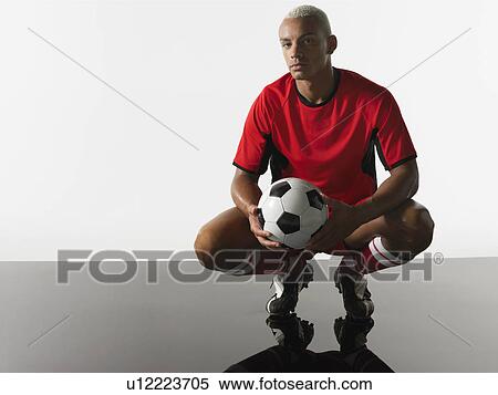 Football player squatting holding ball portrait View Large Photo Image Stock Photography - Football player squatting holding ball portrait. Fotosearch