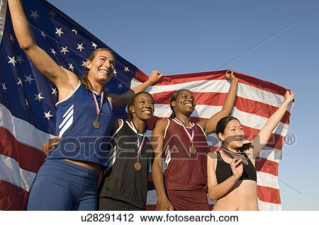 Four female athletes celebrating and holding american flag View Large Photo Image Stock Image - Four female athletes celebrating and holding american flag. Fotosearch