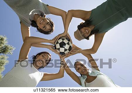 Four women holding soccer ball together view from below. View Large Photo Image Stock Photography - Four women holding soccer ball together view from below.. Fotosearch