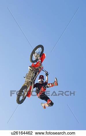 Freestyle motocross racer performing stunt in air View Large Photo Image Stock Image - Freestyle motocross racer performing stunt in air. Fotosearch