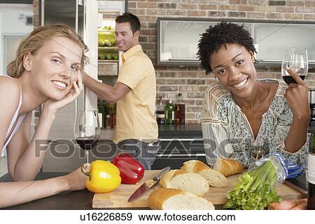 Stock Photo - Friends preparing dinner together portrait. Fotosearch