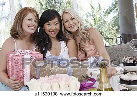 Stock Photo - Friends sitting Together with gifts at Bridal Shower. Fotosearch
