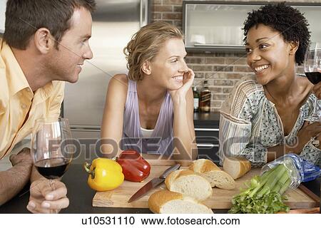 Friends talking while preparing dinner portrait View Large Photo Image Stock Image - Friends talking while preparing dinner portrait. Fotosearch