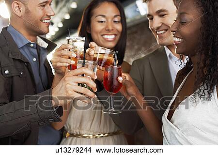 Friends toasting standing at bar View Large Photo Image Picture - Friends toasting standing at bar. Fotosearch