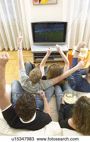 Stock Image - Friends watching TV and celebrating view from above. Fotosearch