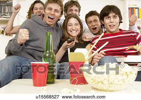 Friends watching TV and celebrating View Large Photo Image Stock Photo - Friends watching TV and celebrating. Fotosearch