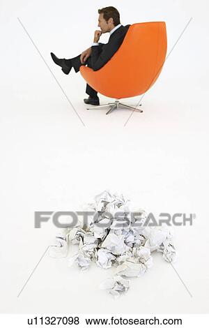 Frustrated businessman sitting by pile of crumpled paper View Large Photo Image Stock Photo - Frustrated businessman sitting by pile of crumpled paper. Fotosearch