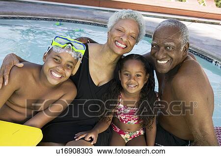 Girl (5-6) boy (10-12) with grandparents at swimming pool portrait. View Large Photo Image Stock Image - Girl (5-6) boy (10-12) with grandparents at swimming pool portrait.. Fotosearch