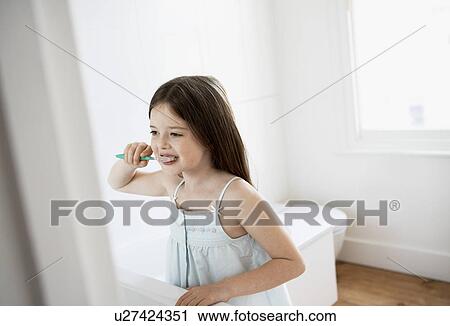 Stock Image - Girl Brushing Teeth in bathroom. Fotosearch