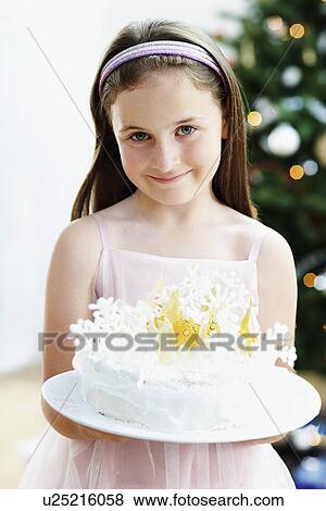 Girl holding Snowflake-Decorated Cake in living room View Large Photo Image Stock Photo - Girl holding Snowflake-Decorated Cake in living room. Fotosearch