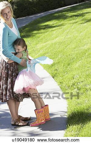 Girl wearing fairy wings and tutu hugging mother in park View Large Photo Image Stock Image - Girl wearing fairy wings and tutu hugging mother in park. Fotosearch