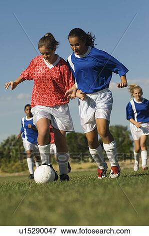Stock Photo - Girls (13-17) playing soccer. Fotosearch