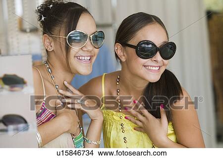 Picture - Girls Trying on Sunglasses in store. Fotosearch