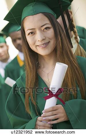 Graduate Holding Diploma outside with others behind portrait View Large Photo Image Stock Image - Graduate Holding Diploma outside with others behind portrait. Fotosearch