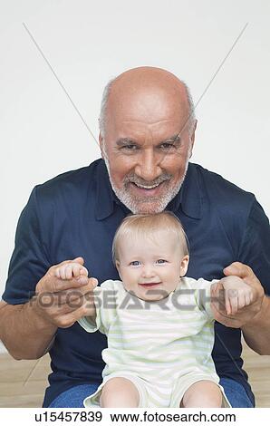 Stock Photo - Grandfather with grandchild on lap. Fotosearch