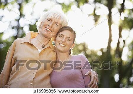 Grandmother and Granddaughter in back yard portrait low angle view View Large Photo Image Stock Photograph - Grandmother and Granddaughter in back yard portrait low angle view. Fotosearch