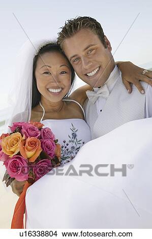 Groom carrying bride outdoors (portrait) View Large Photo Image Picture - Groom carrying bride outdoors (portrait). Fotosearch