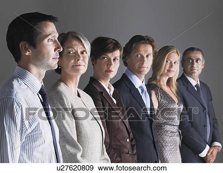 Stock Photo - Group of Businesspeople in a row looking at businessman. Fotosearch