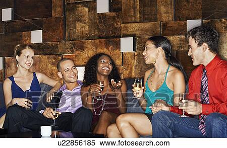Group of friends talking sitting on couch in bar View Large Photo Image Stock Photography - Group of friends talking sitting on couch in bar. Fotosearch