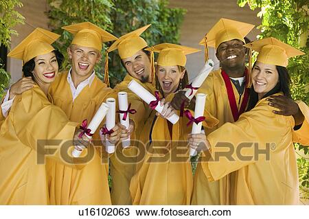 Stock Image - Group of graduates holding diplomas outside portrait. Fotosearch