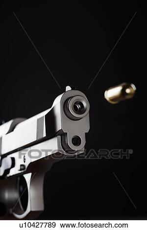 Stock Photo - Gun shooting bullet on black background close up. Fotosearch