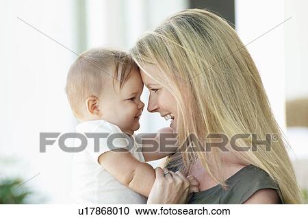 Stock Image - Happy mother and baby smiling into each other's eyes. Fotosearch