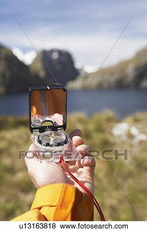Hiker holding compass over trail View Large Photo Image Stock Photo - Hiker holding compass over trail. Fotosearch