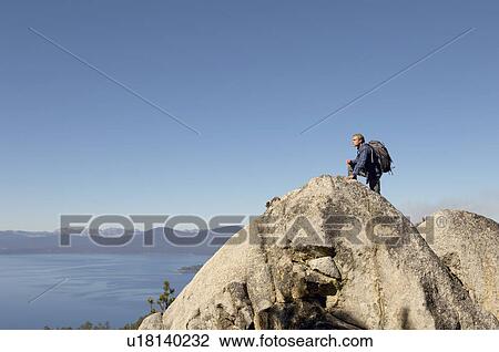 Hiker on boulder at coast View Large Photo Image Stock Image - Hiker on boulder at coast. Fotosearch