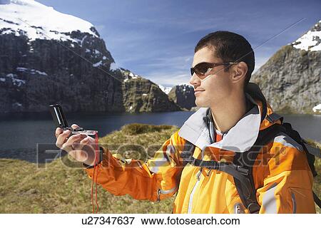 Hiker using compass in mountains View Large Photo Image Stock Photo - Hiker using compass in mountains. Fotosearch