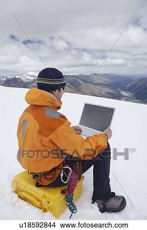 Hiker using laptop on snowy mountain peak back view View Large Photo Image Picture - Hiker using laptop on snowy mountain peak back view. Fotosearch